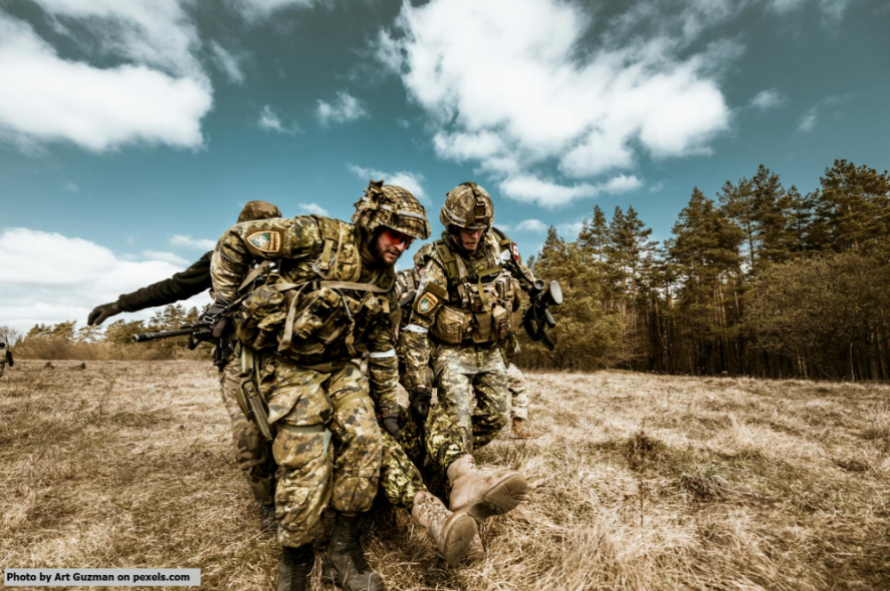 Soldiers carrying another to safety.